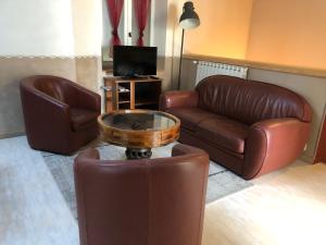 sala de estar con sofá de cuero y mesa de centro en Le Moulin de Milan en Cheval-Blanc