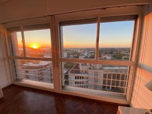 Cette chambre dispose de deux fenêtres offrant une vue sur le coucher du soleil. dans l'établissement Vista a Montevideo, à Montevideo