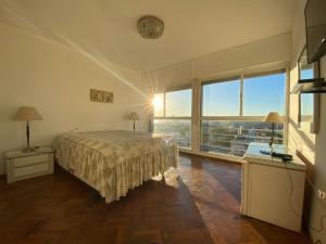 a bedroom with a bed and a large window at Vista a Montevideo in Montevideo