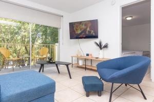 een woonkamer met een blauwe stoel en een tafel bij One Bedroom Apartment - with Parking & Balcony - Heart of Wynwood in Miami