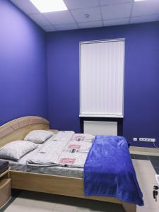 1 dormitorio con 1 cama con pared azul en Старий Дворик,кімнати біля жд вокзалу, en Leópolis