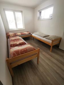 2 Betten in einem Zimmer mit 2 Fenstern in der Unterkunft Apartment J&D in Dunajská Streda