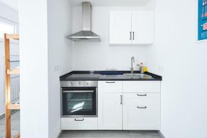 - une cuisine blanche avec évier et cuisinière dans l'établissement Sintra Sweet Apartment I - Free Parking, à Sintra
