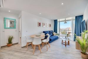 salon z niebieską kanapą, stołem i krzesłami w obiekcie VB Diana 1BR Marina & Sea views w mieście Benalmádena