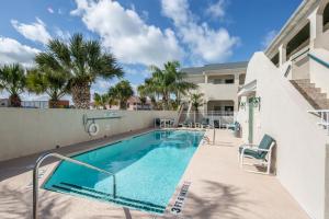 una piscina en el patio de un edificio con palmeras en Rain Dancer en South Padre Island