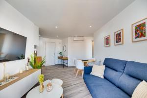 salon z niebieską kanapą i stołem w obiekcie VB Diana 1BR Marina & Sea views w mieście Benalmádena