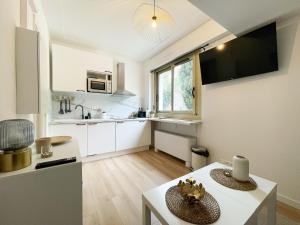 uma cozinha com armários brancos e uma mesa branca em Studio bord de mer 2 em Menton