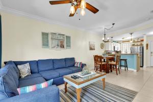 a living room with a blue couch and a table at Rain Dancer in South Padre Island