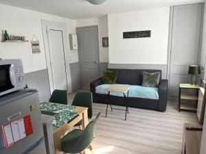 ein Wohnzimmer mit einem Sofa und einem Tisch in der Unterkunft Gîte Lilou avec parking privé in Le Tréport