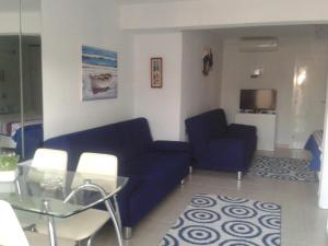 サルティにあるRudi Studiosのリビングルーム(青いソファ、テーブル付)