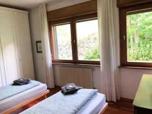 2 Betten in einem Zimmer mit 2 Fenstern in der Unterkunft VILLA ADA (Val di Sole, Cogolo di Peio) in Cogolo