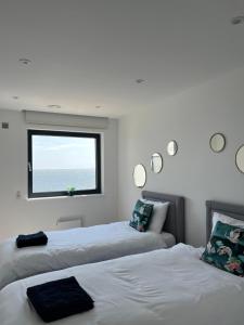 two beds in a room with a window at Royal View in Ramsgate