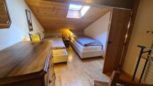 a small attic bedroom with two beds and a window at Chez Pewee, beau duplex en ville, parc privé in Martigny-Ville