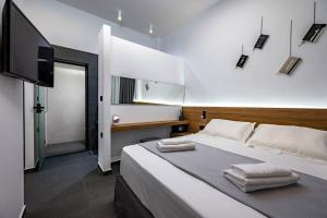 a bedroom with a large bed with a flat screen tv at Poem in Kos Town