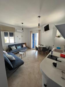 ein Wohnzimmer mit einem Sofa und einem Tisch in der Unterkunft Aegean Breeze Kythnos Greek small apartment in Mérikhas