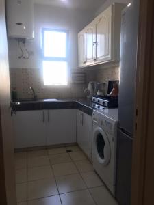 a kitchen with a washing machine and a window at Ceuta fnideq in Fnidek