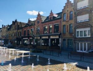 a group of buildings with a fountain in front of it at B&B East&West in Ypres