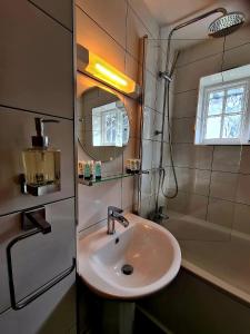 a bathroom with a sink and a bath tub at The St Crispin Inn in Worth