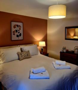 ein Schlafzimmer mit einem großen Bett mit Handtüchern darauf in der Unterkunft The St Crispin Inn in Worth