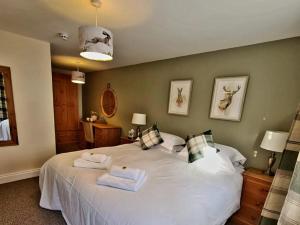 a bedroom with a large white bed with towels on it at The St Crispin Inn in Worth