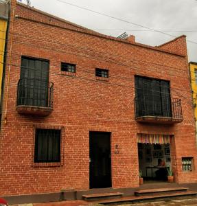 ein rotes Backsteingebäude mit zwei Balkonen in der Unterkunft Hotel Casa Acueducto - Lujo Cultural in Oaxaca de Juárez