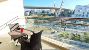 balcón con mesa, sillas y vistas a la ciudad en Bridge apartments, en Amán