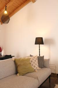 um sofá numa sala de estar com um candeeiro em Birdy House em Faro