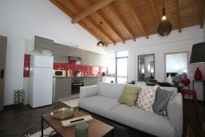 a living room with a couch and a kitchen at Birdy House in Faro