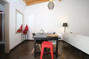 uma sala de jantar com uma mesa e um banco vermelho em Birdy House em Faro
