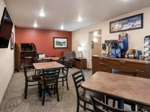 My Place Hotel-Lubbock, TX في لوبوك: غرفة بالفندق بها طاولات وكراسي ومطبخ