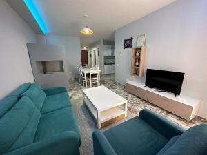 a living room with a blue couch and a tv at Dream Apartments Shengjin in Shëngjin