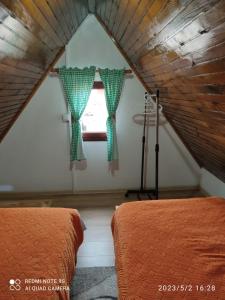 a attic bedroom with two beds and a window at Apartments Snowflake in Žabljak