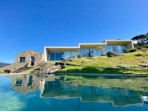 a house on a hill with a reflection in the water at Casa do Vale de Cerdeiras in Ancede