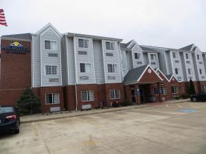 a row of apartment buildings in a parking lot at Microtel by Wyndham South Bend Notre Dame University in South Bend