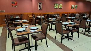 une salle à manger avec des tables et des chaises en bois dans l'établissement Hotel Diego de Almagro Copiapo, à Copiapó