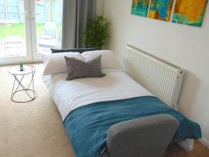 - un lit dans une chambre avec fenêtre dans l'établissement Cosy Two Bedroom Bungalow in Hutton Brentwood with Free Parking & Garden, à Hutton