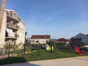 einen Spielplatz in einem Hof neben einem Apartmentgebäude in der Unterkunft Lux Apartment Jovanovic in Tivat