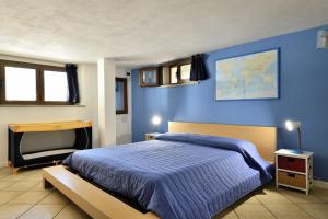 Dormitorio azul con cama y escritorio en Casa Oleandri, en Santa Maria Navarrese