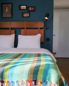 een slaapkamer met een bed met een kleurrijke deken bij The Abies in Canakkale