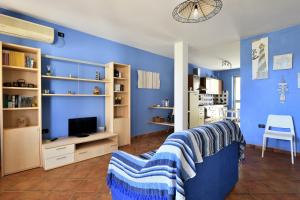 Sala de estar azul con sofá y TV en Casa Oleandri, en Santa Maria Navarrese