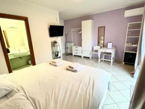 1 Schlafzimmer mit einem weißen Bett und einem Badezimmer in der Unterkunft Cape House in Albano Laziale