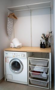 - une buanderie avec un lave-linge et un sèche-linge dans l'établissement Design Apartment Alpenvorstadt, à Holzkirchen