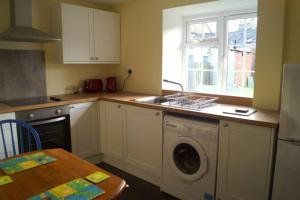 a kitchen with a washing machine and a sink at The Stables, 2 Plough Square in Glanton