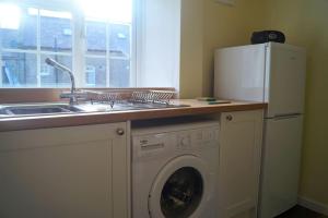 a kitchen with a sink and a washing machine at The Stables, 2 Plough Square in Glanton +40 photos
