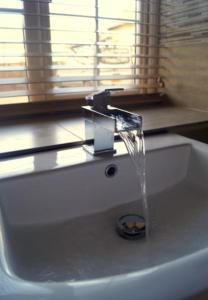 a sink with a water faucet in a bathroom at The Stables, 2 Plough Square in Glanton