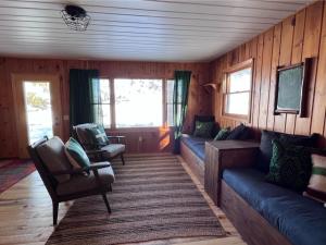 ein Wohnzimmer mit einem Sofa, Stühlen und Fenstern in der Unterkunft Kona Kona Resort & Cabins in Laporte