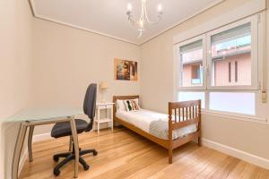 a bedroom with a desk and a bed and a window at Apartamento reformado en zona residencial con garaje y wifi in Bilbao