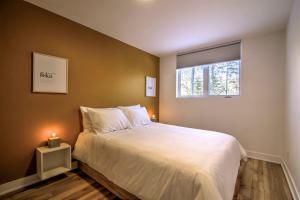 - une chambre avec un grand lit blanc et une fenêtre dans l'établissement Chalet Haut-Bois - Hiking, Skiing and Spa, à Morin Heights