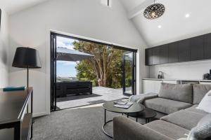 a living room with a couch and a table at The Ridge in Mangawhai