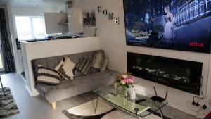 uma sala de estar com um sofá e uma mesa de vidro em Milton Keynes Luxury Short Stay House with WIFI and Free Parking em Wolverton
